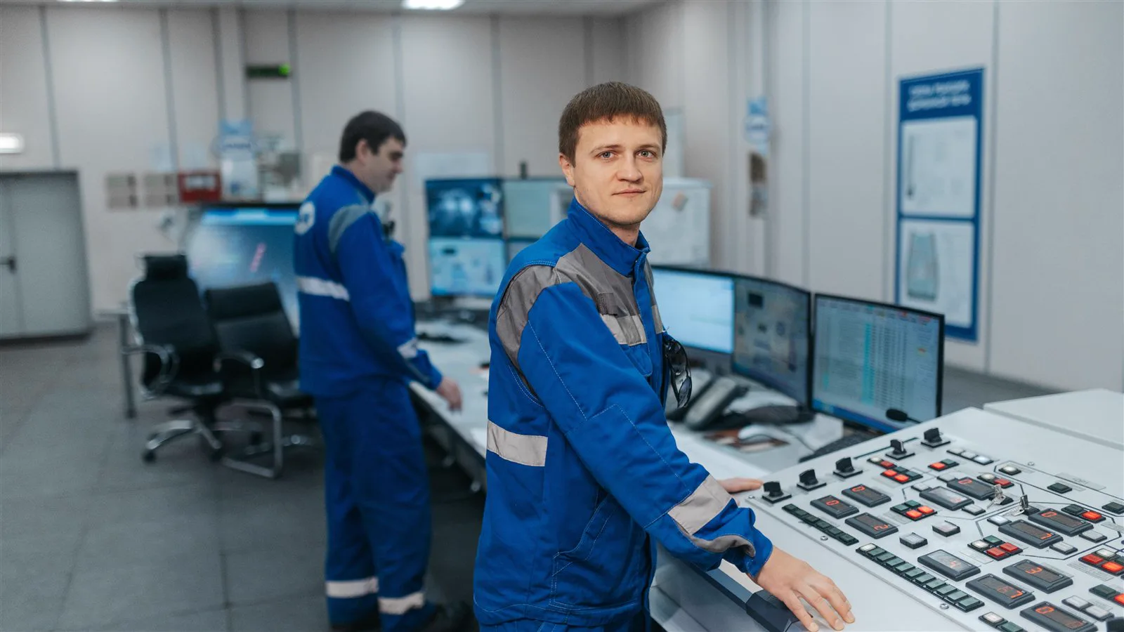 Rail operations technicians monitoring system status on multiple screens in a control room